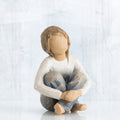 Little girl figurine sitting with legs crossed - faceless - wearing white shirt and blue jeans
