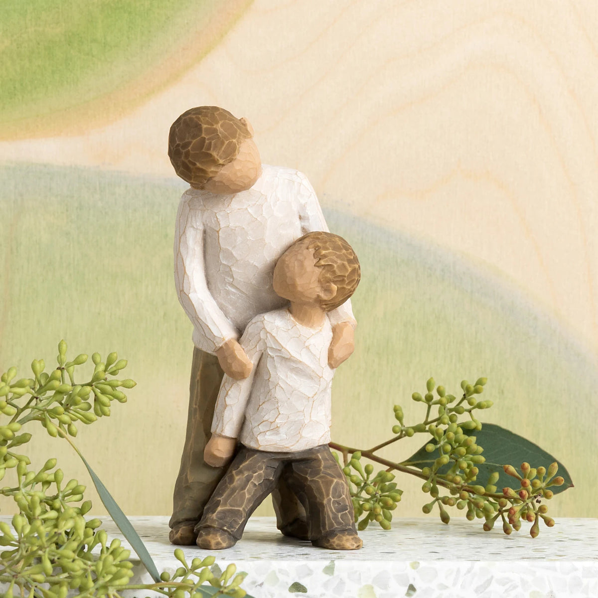 Willow Tree Brothers, 5"h hand-painted resin figure of two boys, younger leaning against older, both dressed in neutral colors, in front of green painting