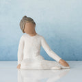 Faceless woman figurine in white dress sitting don on her knees - blue background