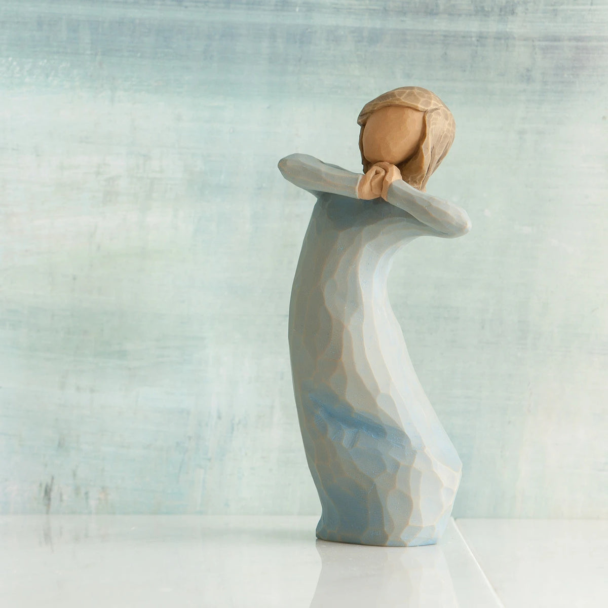 Willow Tree Journey, 5.5”h hand-painted standing resin figure in blue dress, arms raised up to face as if dancing, in front of blue/grey painting