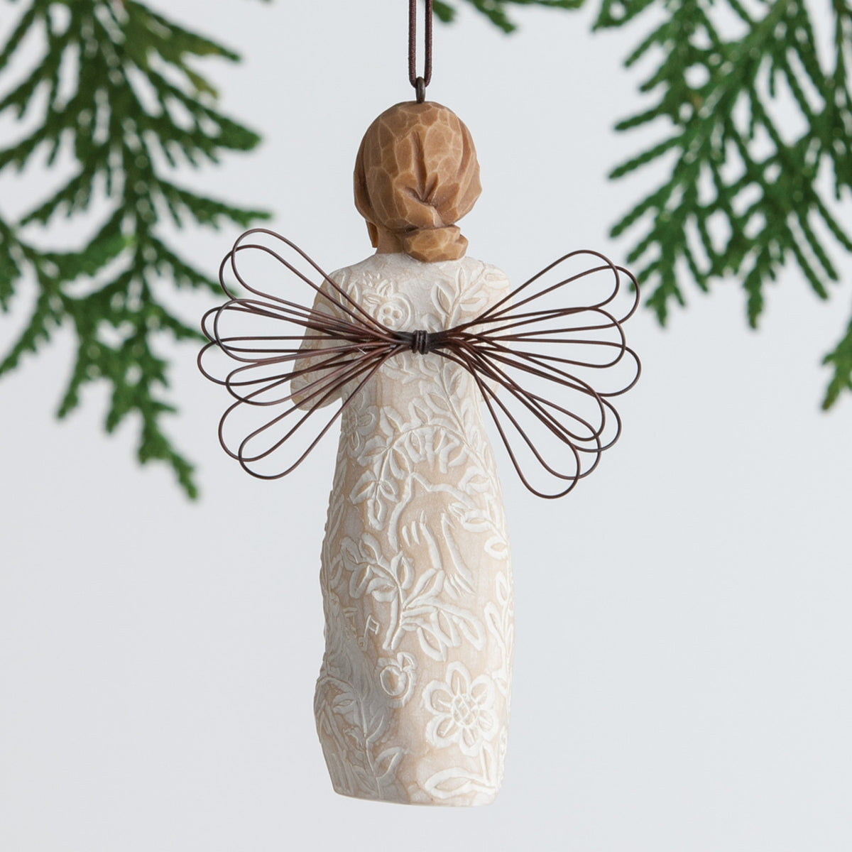 Back view of brunette girl ornament with brown wings hanging from tree branch