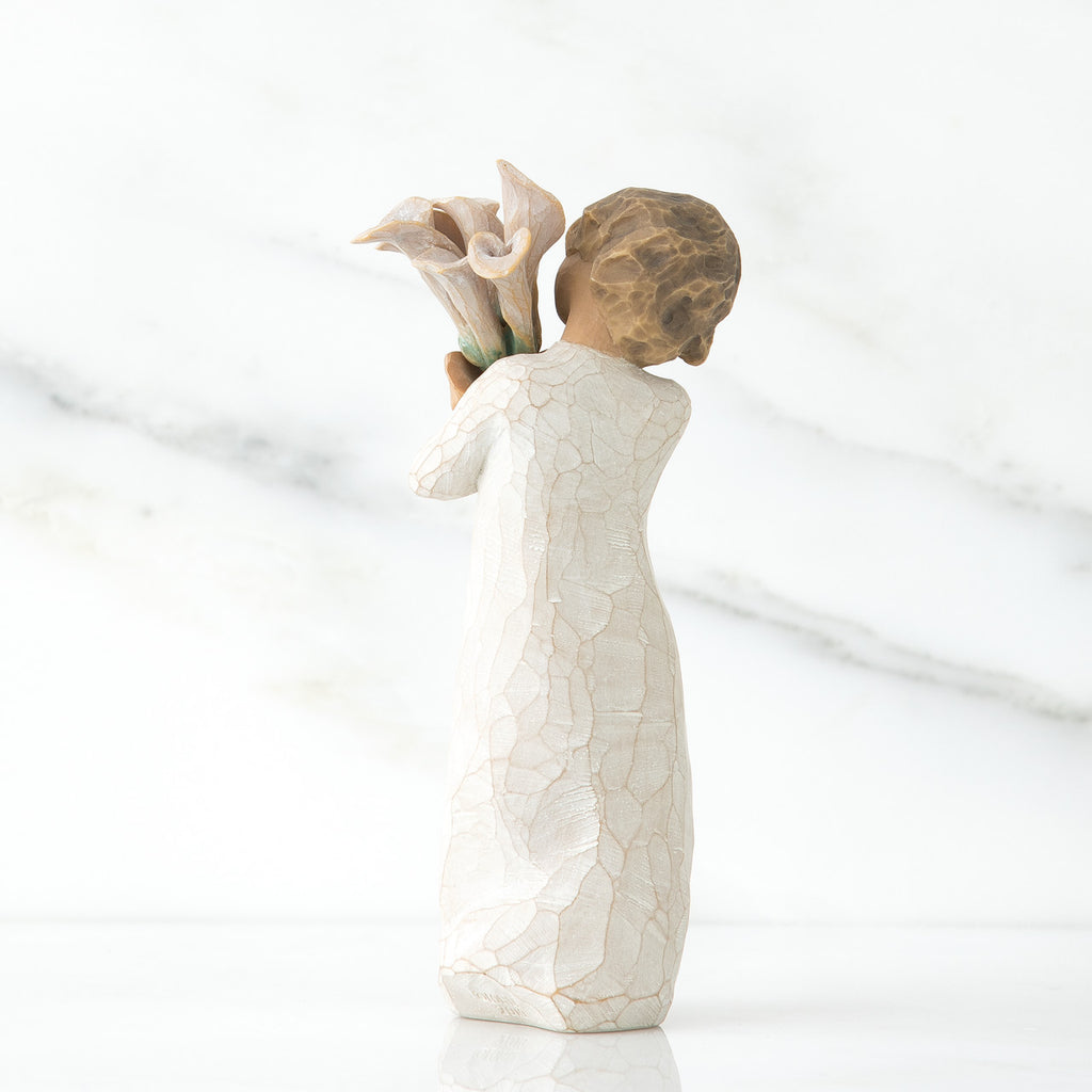 Back view of lIttle girl with short brown hair holding a cluter of white calla lilies