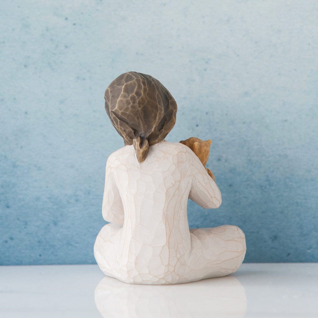 Small brunette girl in white facing away from the front towards the blue wall