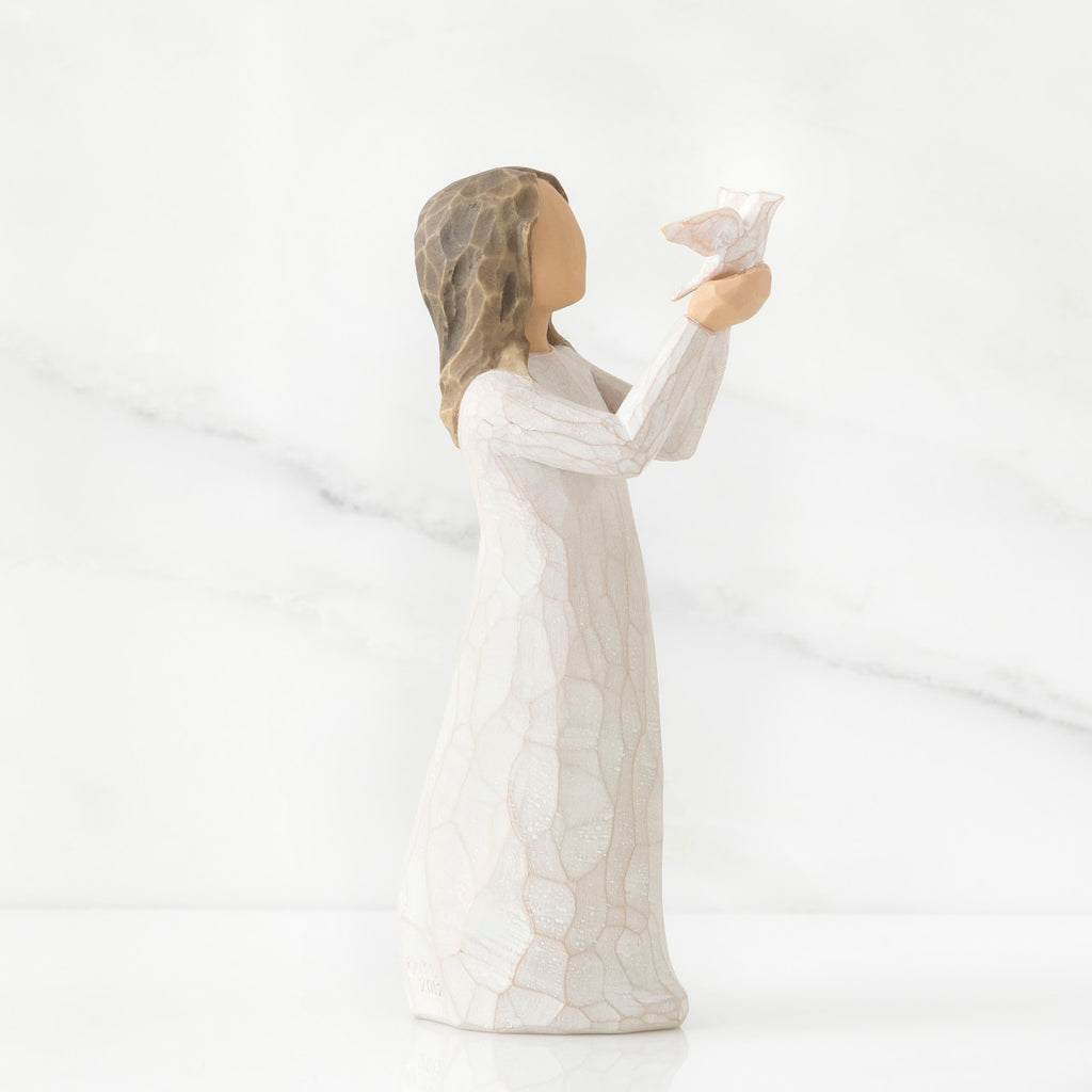 Side view of brunette woman in white dress holding up white bird