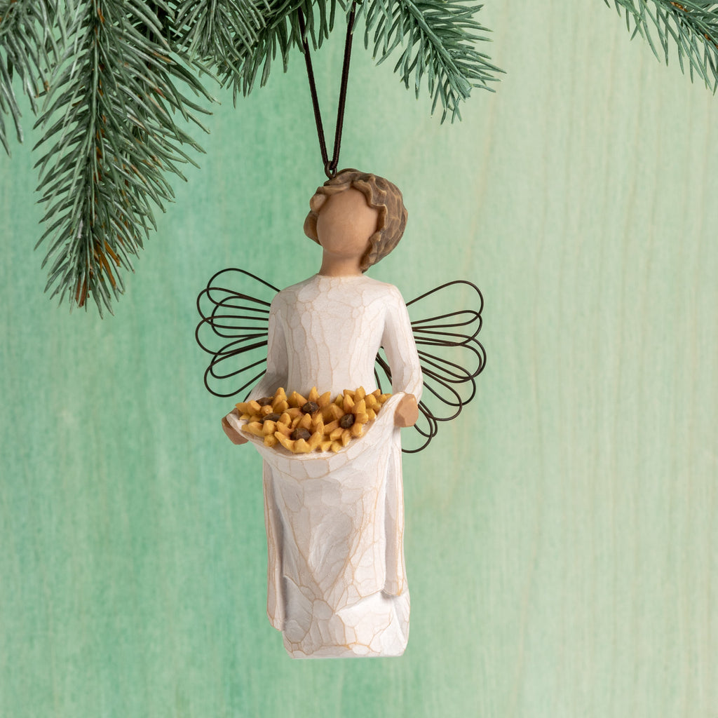Front view: female figure with wire wings, holding skirt filled with yellow sunflowers; hook and loop affixed to head