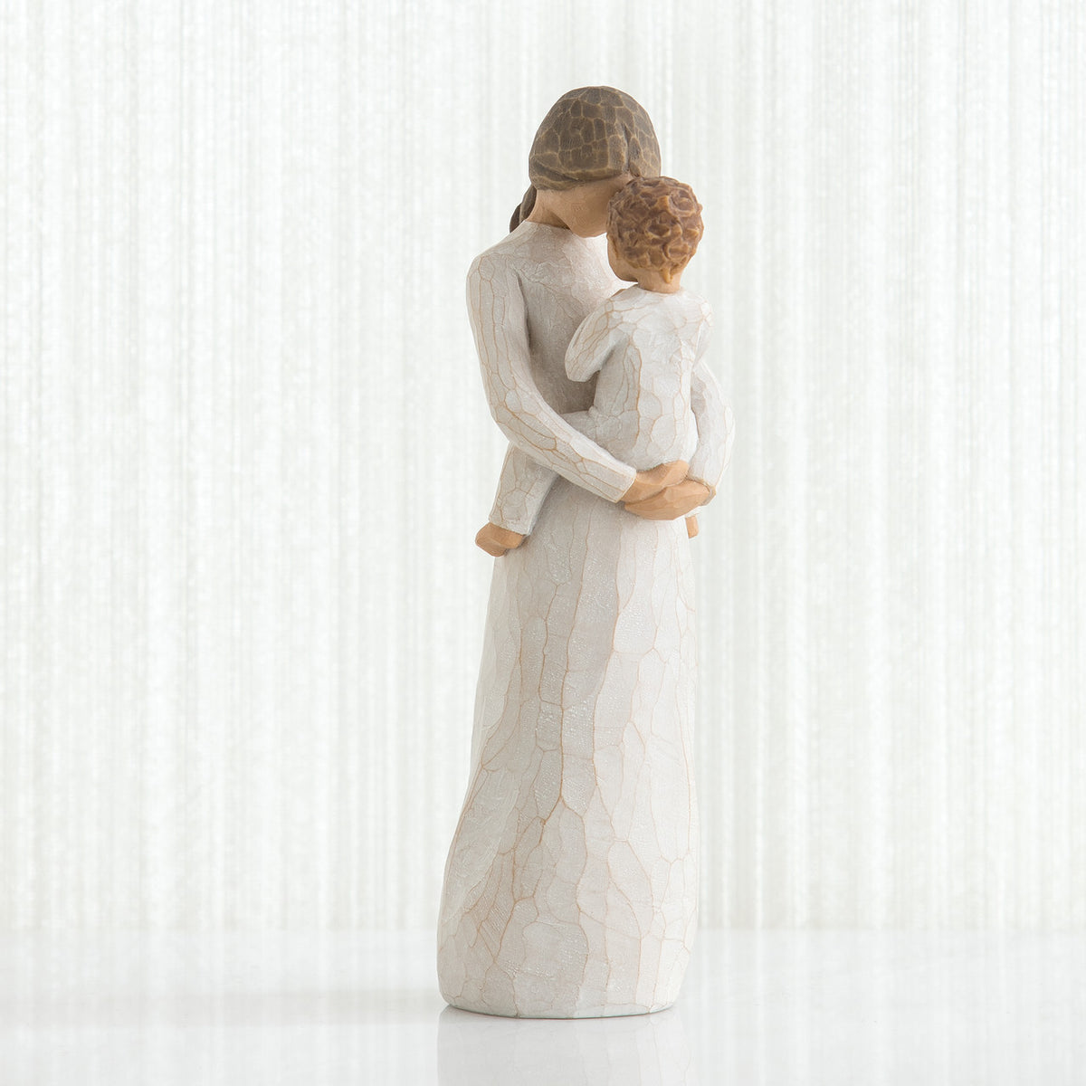 Woman figurine in white dress holding small child