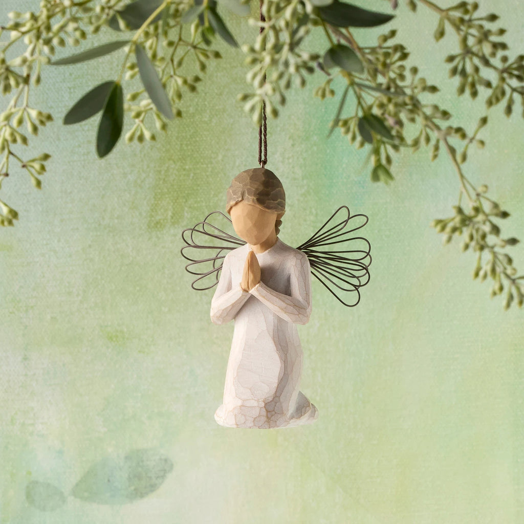 Willow Tree Angel of Prayer Ornament, 3"h hand-painted kneeling resin figure in cream dress with wire wings, hands in prayer position, brown elastic cord, hanging in front of green painting