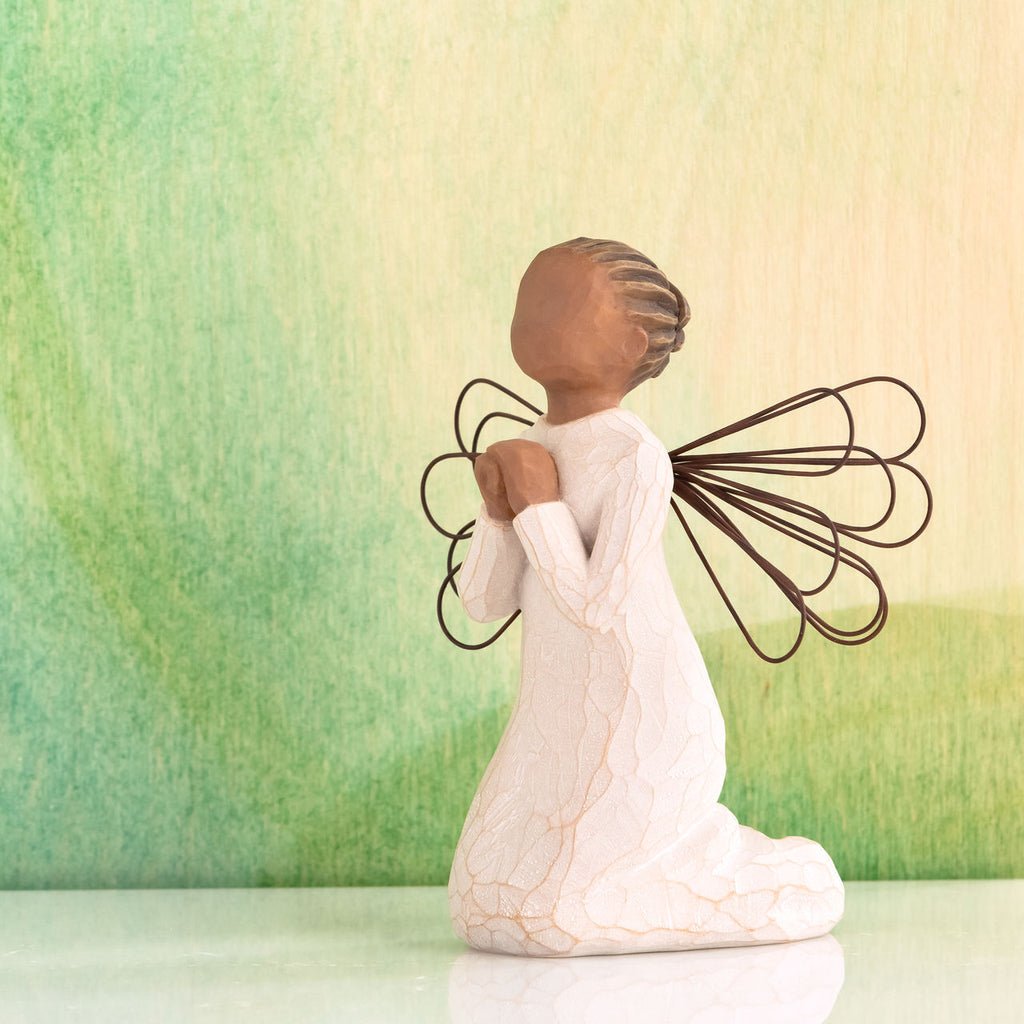 Willow Tree Angel of the Spirit, 4"h hand-painted resin kn eeling figure with darker skin and hair, in cream dress with wire wings, looking upwards with hands in prayer position, green painting in background