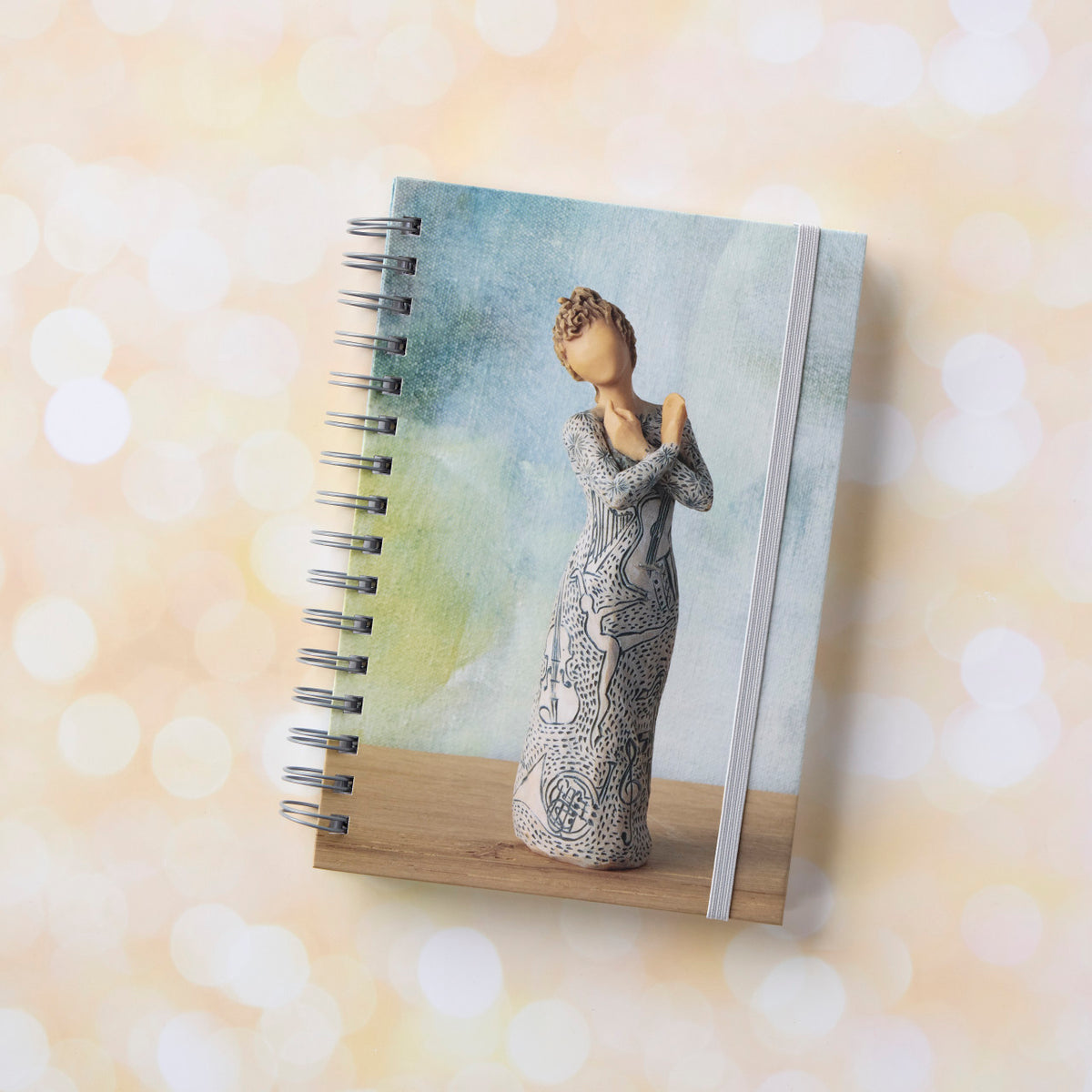 Willow Tree Music Speaks Notebook, 6.5"w x 8.5"h, hard-cover, spiral-bound, 240 lined pages, front cover features Music Speaks figure on background of blue-green painting