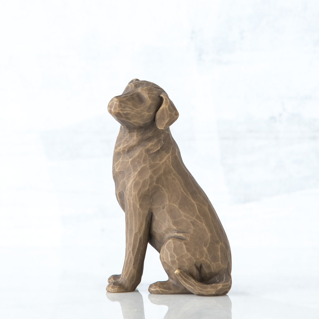 Dark brown dog figurine sitting from the side