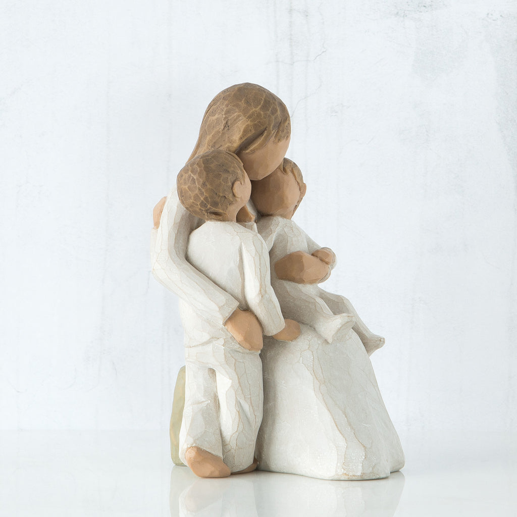 Brunette woman figurine with arms around two children all sitting down