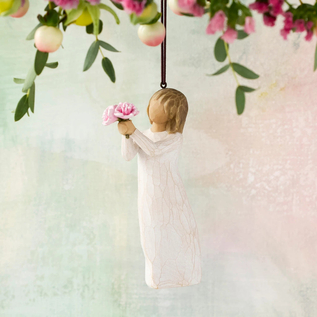 Willow Tree Thank You Ornament, 4”h hand-painted resin figure in cream dress, holding out bouquet of pink peonies, brown elastic cord, hanging in front of pastel painting