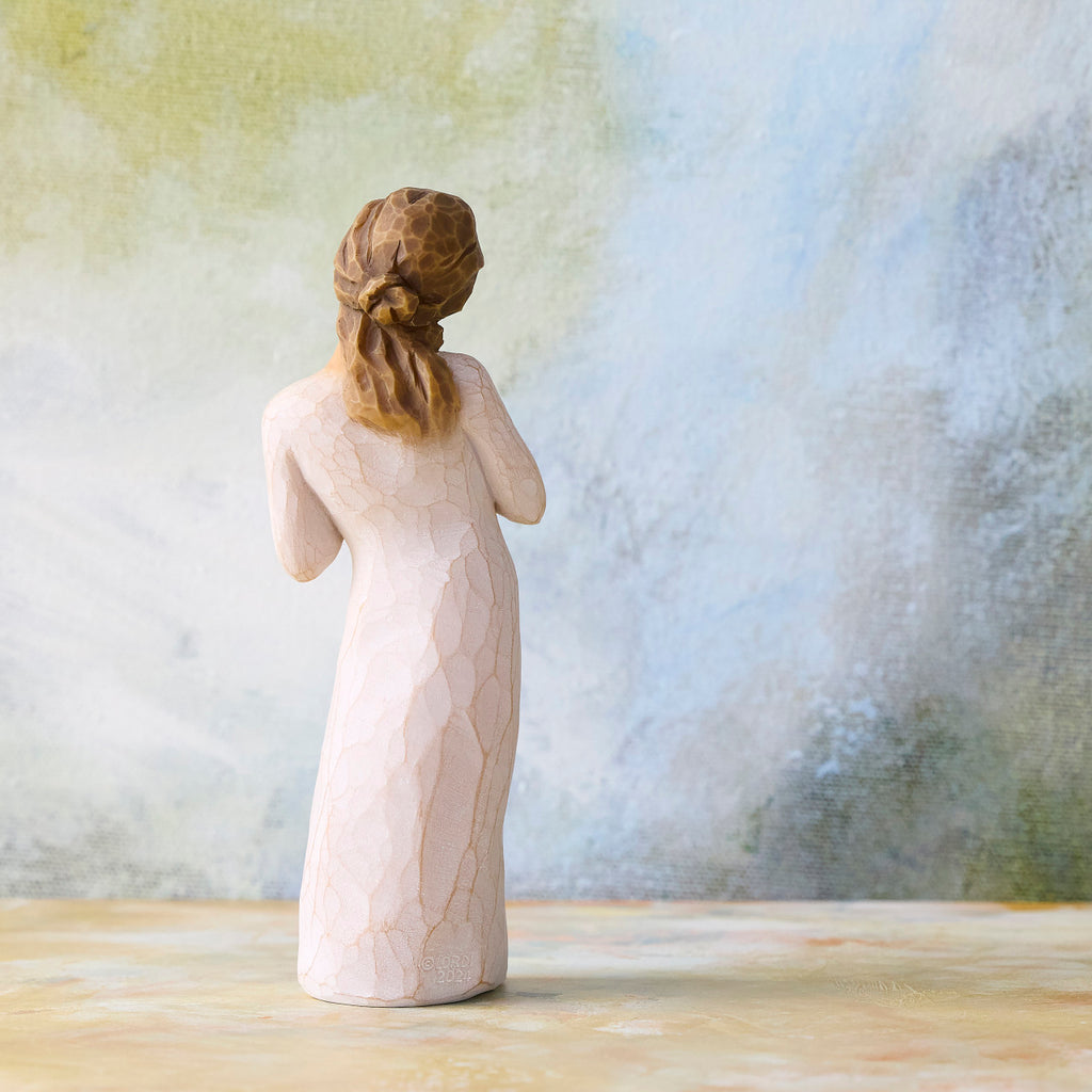 Willow Tree Here for You, back view of 5”h hand-painted standing figure in cream dress, hands to heart in empathetic gesture, in front of blue-green painting