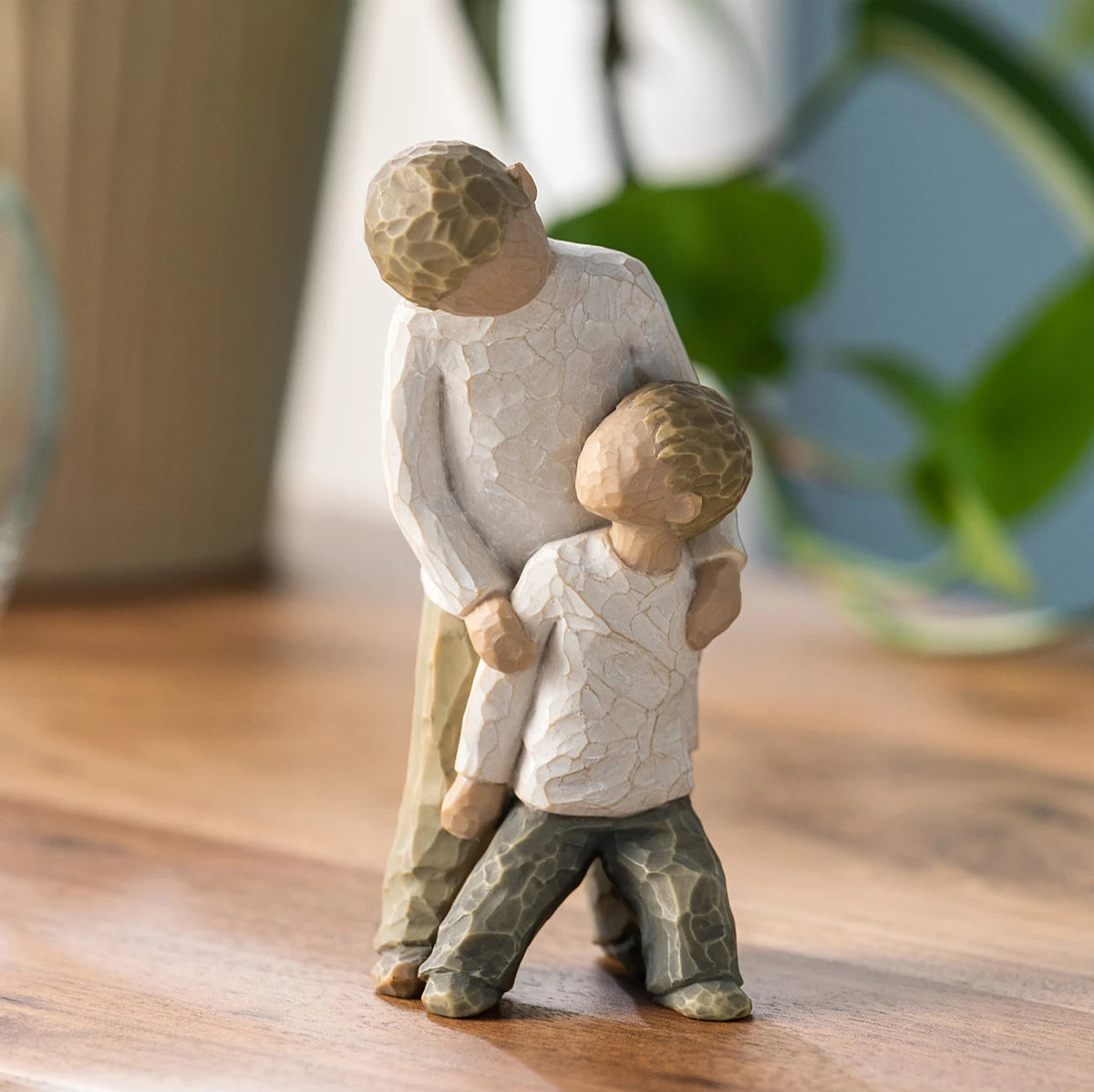 Willow Tree Brothers, 5"h hand-painted resin figure of two boys, younger leaning against older, both dressed in neutral colors, on wooden table