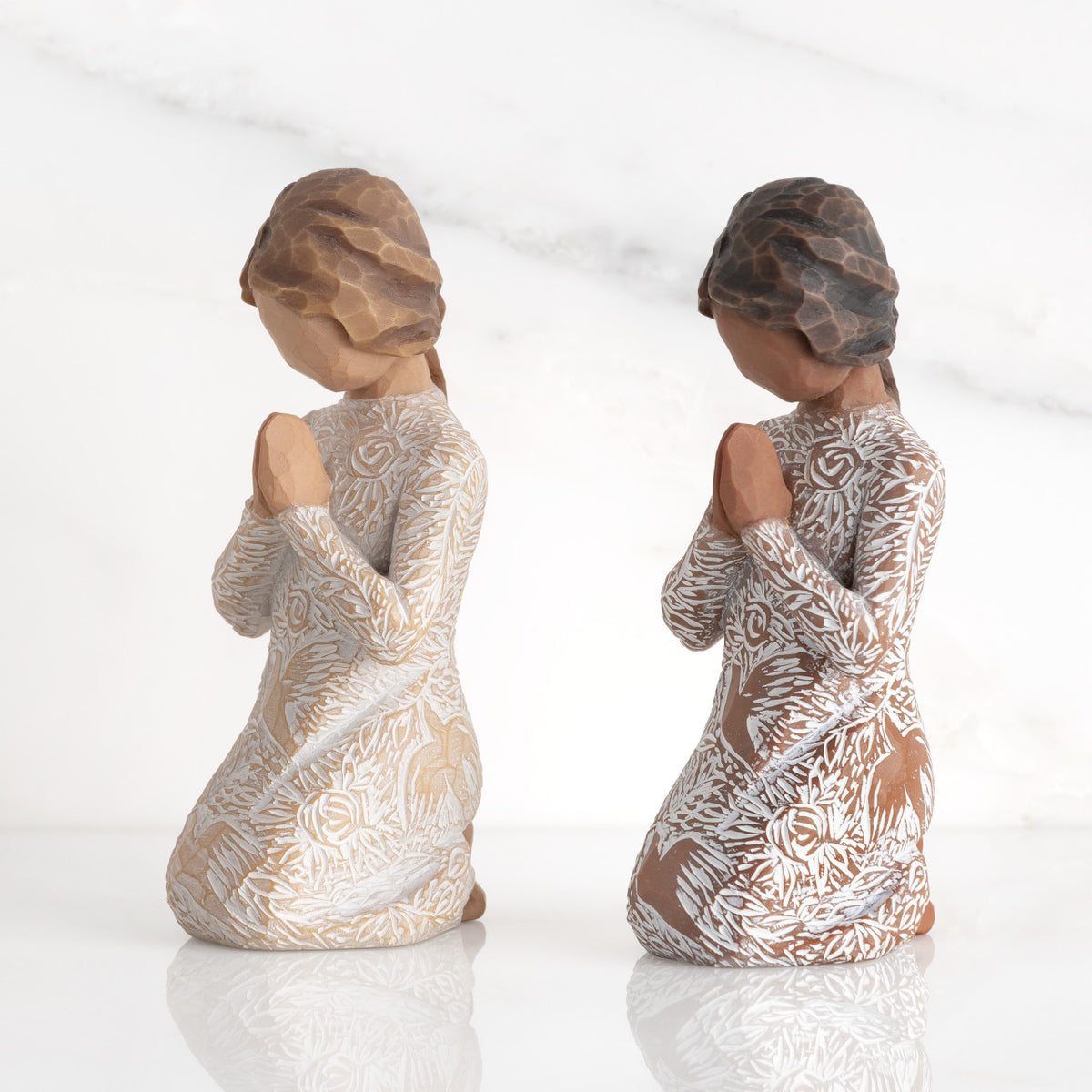 Lighter & Darker skin Kneeling figures, hands in position of prayer or meditation in cream dress carved with icons of nature, lighter and darker skin versions