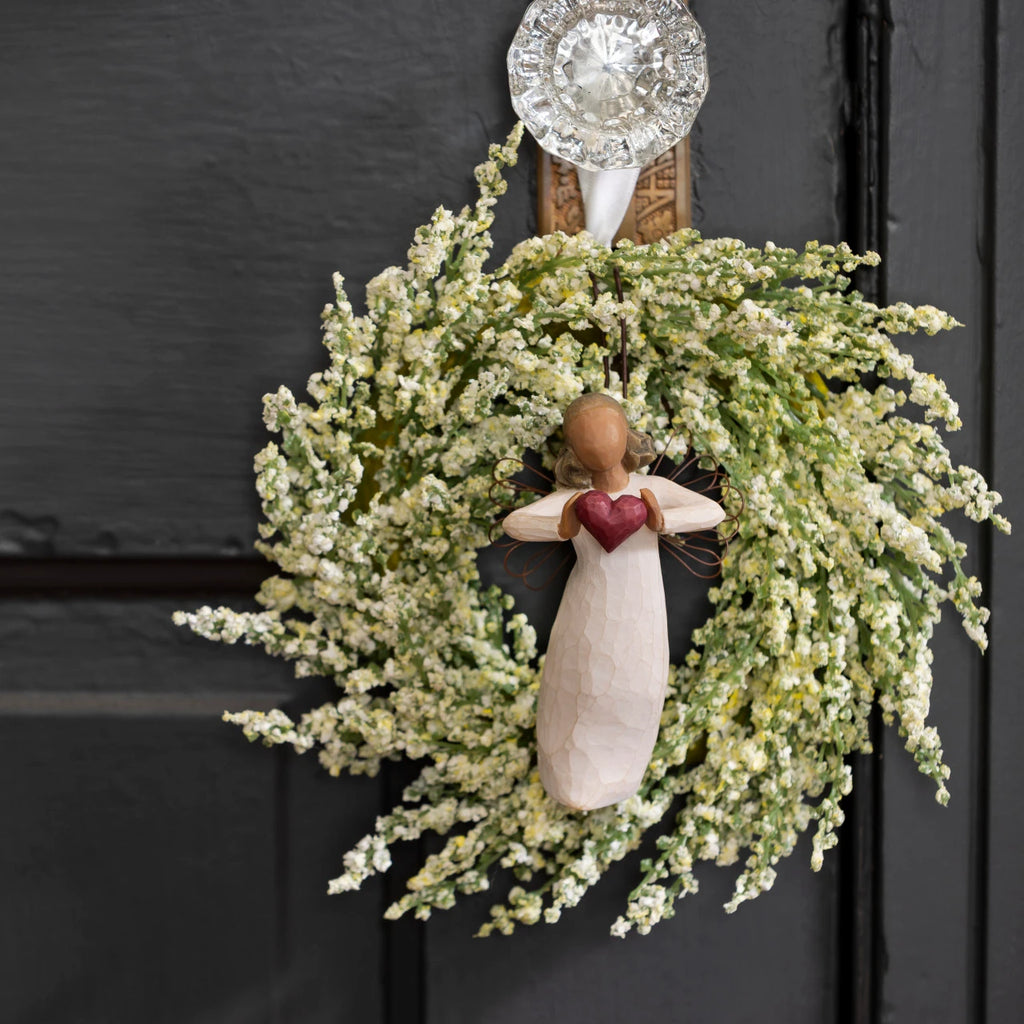 Willow Tree With Love Ornament, 4”h hand-painted resin angel figure with darker hair and skin, in cream dress, wire wings, holding red heart, brown elastic cord, hanging inside spring wreath