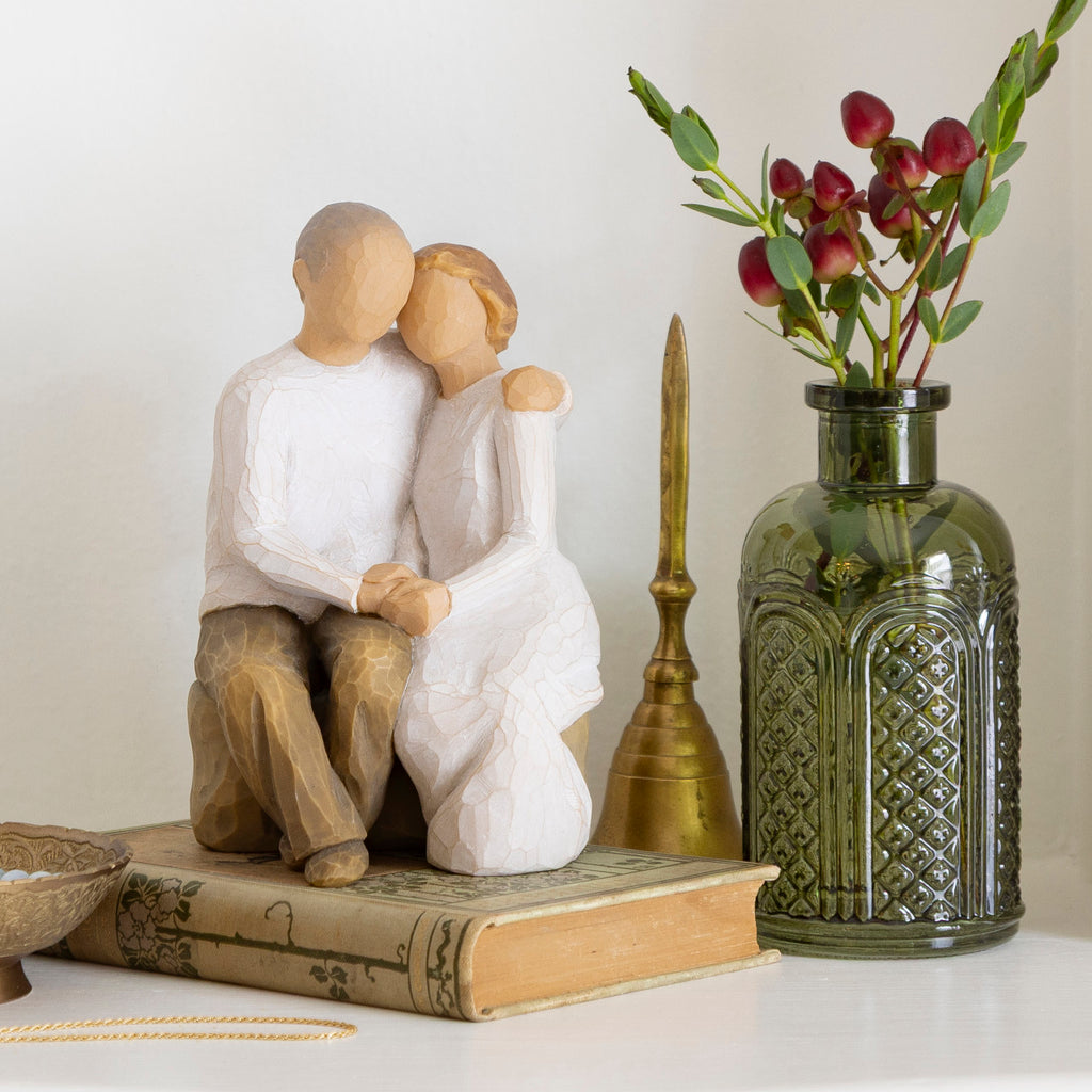 Willow Tree Anniversary, 6”h hand-painted resin figure of older couple sitting on bench holding hands, both in neutral clothing, on table with mementos