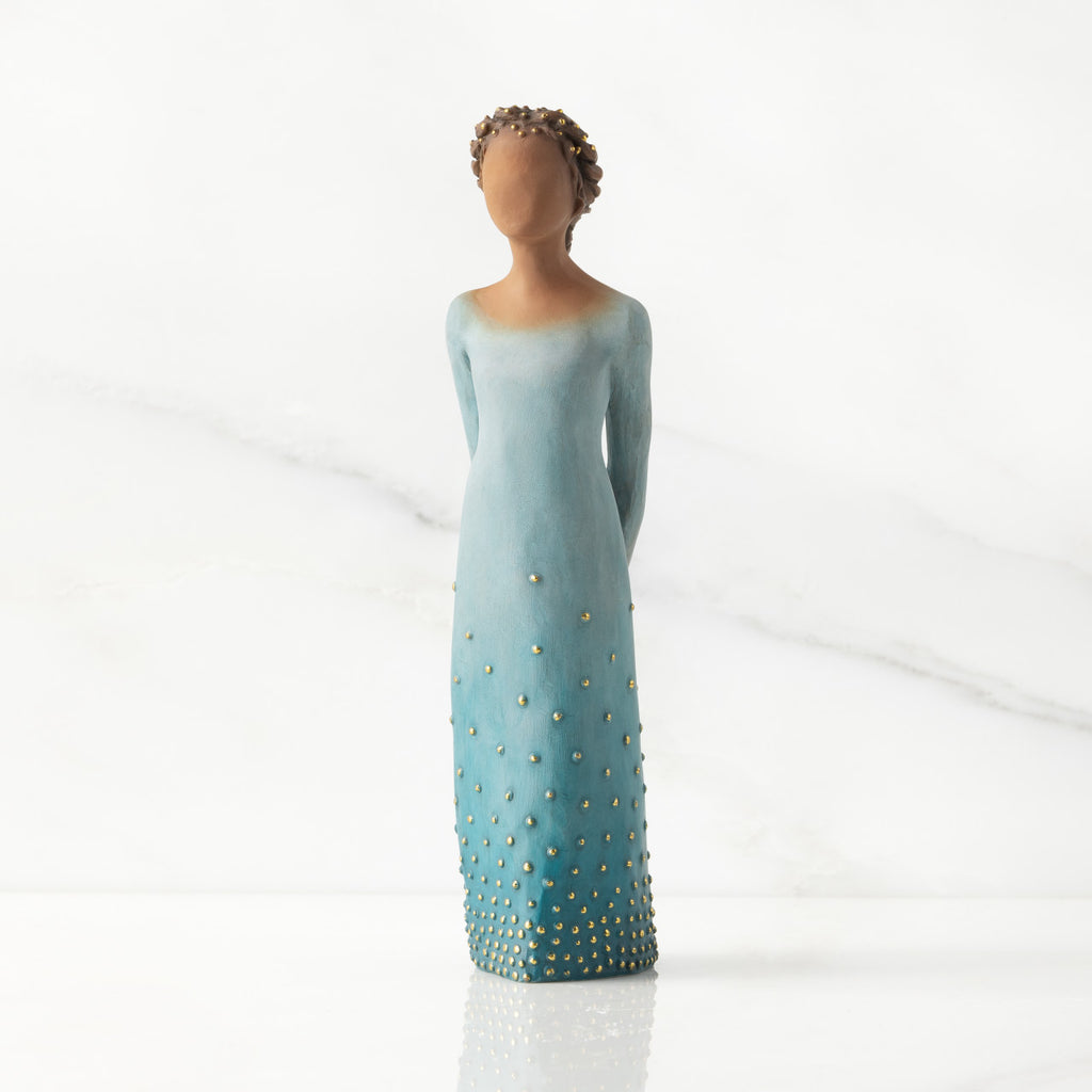 Facing front: Darker-skin figure, arms clasped behind back, hair and deep blue ombré garment dotted with gold leaf